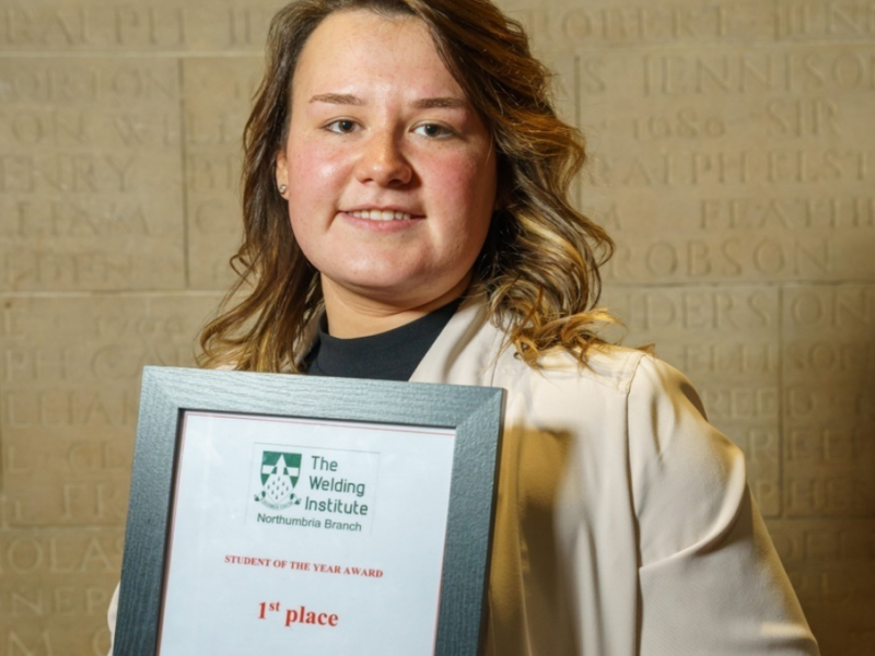 Courtney Newton holding award from The Welding Institute